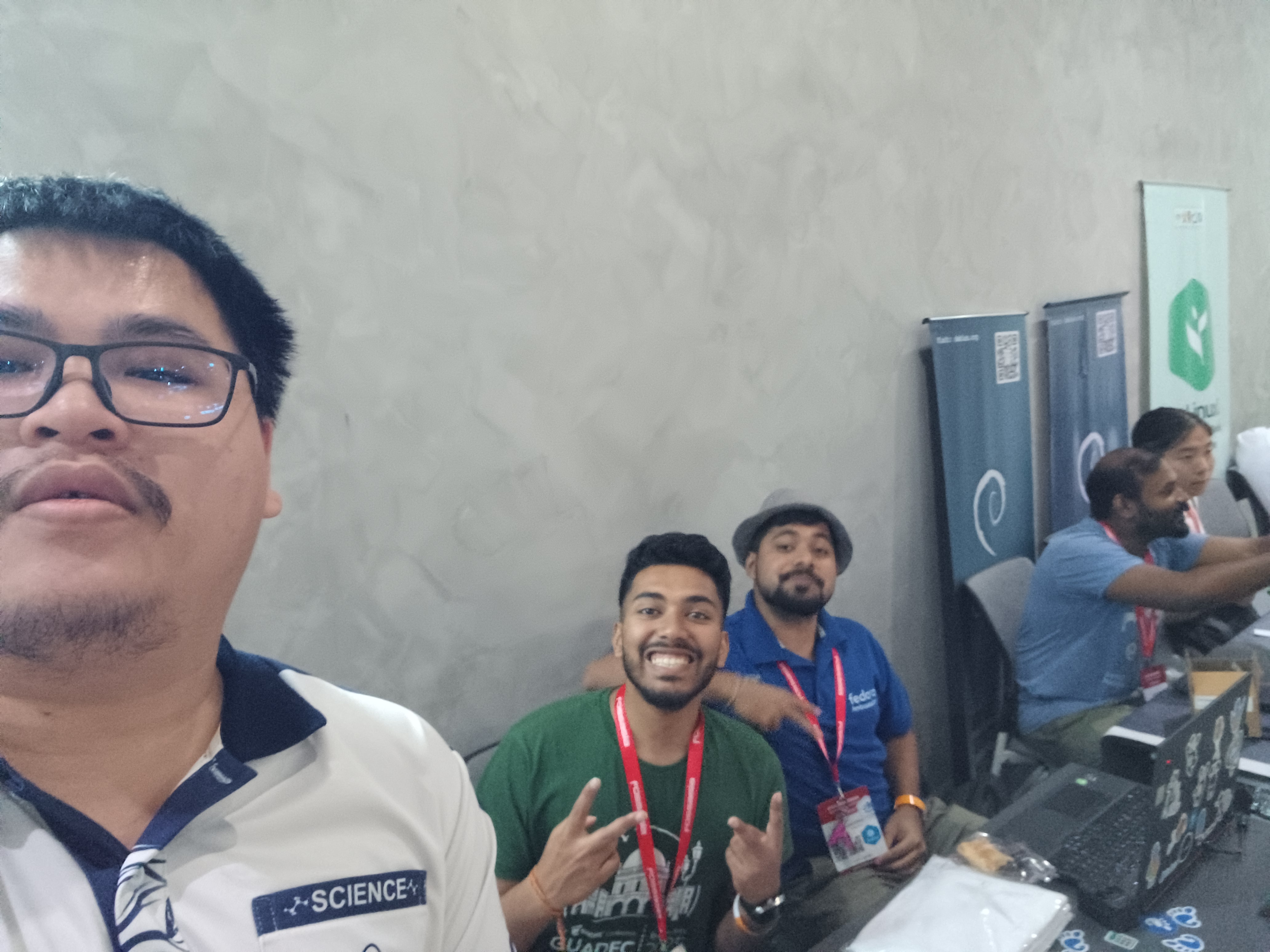 A selfie of me and the people at the GNOME booth, with me being slightly out of frame and looking too high up because of my horrid selfie skills